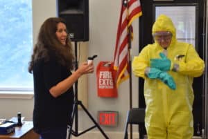 Kathy Shea from AK DEC demonstrates use of personal protection equipment